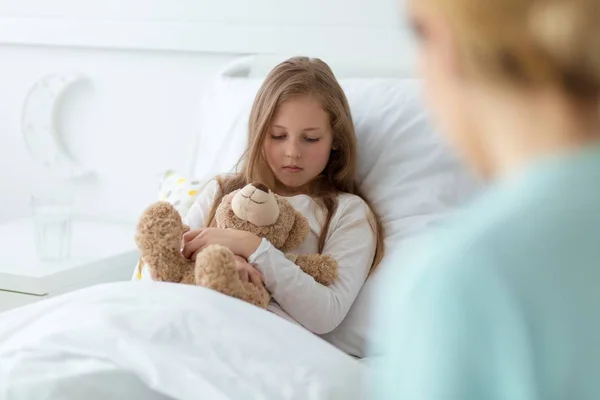 Kid with a teddy bear afraid of a diagnosis — Stock Photo, Image