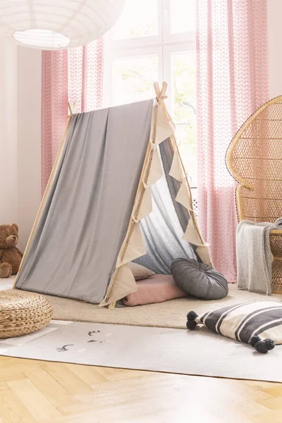 Szary namiot Scandi w Cute Little Girl pokój zabaw z wikliny Peacock krzesło, poduszki i dywany, prawdziwe zdjęcie — Zdjęcie stockowe