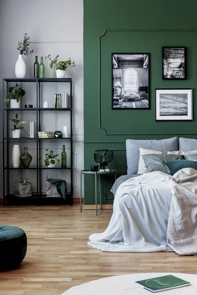 Galerie de poster noir et blanc sur mur vert derrière lit king size avec oreillers et couverture — Photo