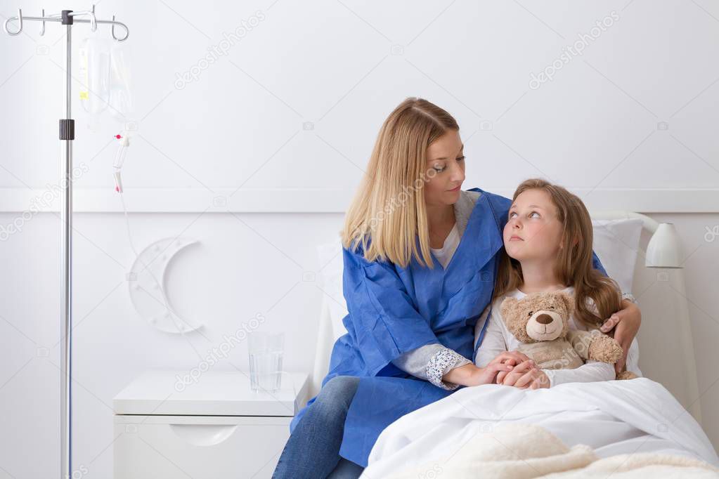 Girl in the hospital and mother holding her hand