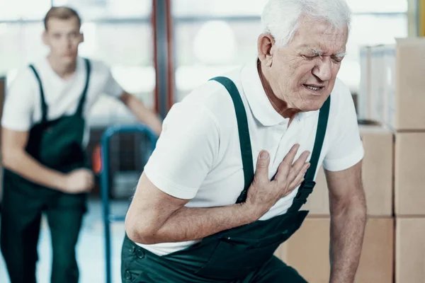 Senior Magazijnier met een hartaanval op het werk — Stockfoto