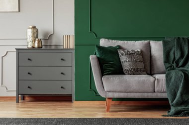Yeşil duvar, gri Iskandinav kanepe ve şık oturma odası iç çekmeceler ahşap göğüs