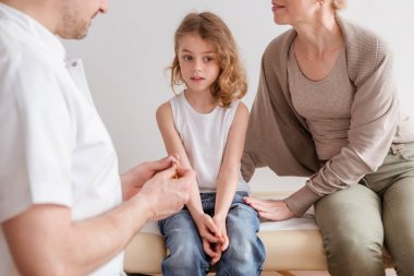 Onun sevgi dolu annesi ile pediatrist ofisinde grip ile hasta sevimli küçük çocuk