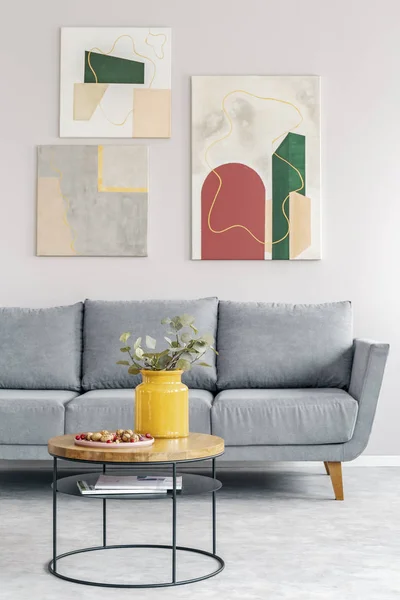 Mesa de centro em frente ao sofá cinzento na sala de estar escandinava — Fotografia de Stock