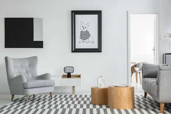 Άνετη γκρίζα πολυθρόνα στο κομψό εσωτερικό σαλόνι με λευκά έπιπλα και δύο ξύλινα τραπέζια καφέ — Φωτογραφία Αρχείου