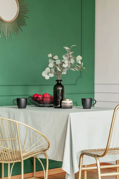 Eettafel met fruit in een kom, bloemen in vaas en koffie mokken — Stockfoto