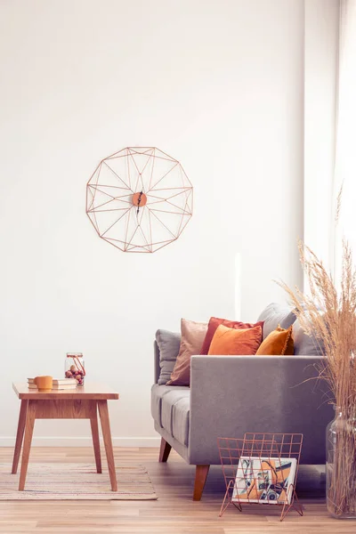 Fancy clock on white wall of elegant living room interior