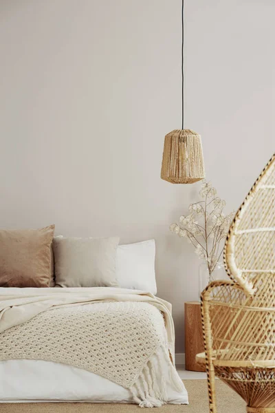 Silla de pavo real, lámpara de mimbre y cama acogedora, espacio para copiar en la pared vacía — Foto de Stock