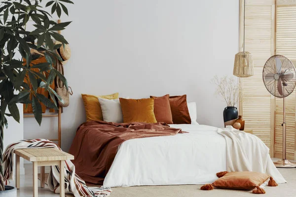 Almofadas coloridas de outono na cama king size no interior do quarto chique — Fotografia de Stock