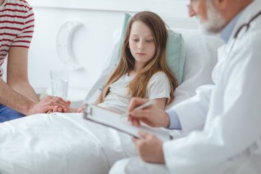 Doktor bir çocuğa nasıl ilaç almakla ilgili açıklamaya