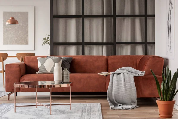 Stylowa, brązowa sofa narożna z wzorzystymi poduszkami w eleganckim salonie z ścianą słupki — Zdjęcie stockowe