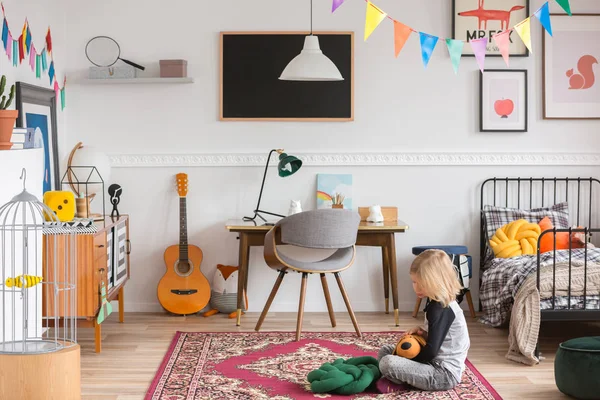 Petit enfant assis sur le tapis dans la chambre blanche avec vintage — Photo