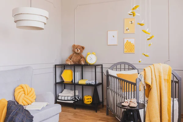Stijlvolle grijze en gele baby slaapkamer met wieg en industriële zwarte metalen plank — Stockfoto