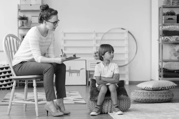 Psicoterapeuta que analiza el comportamiento del niño con TDAH durante la terapia. Foto en blanco y negro — Foto de Stock