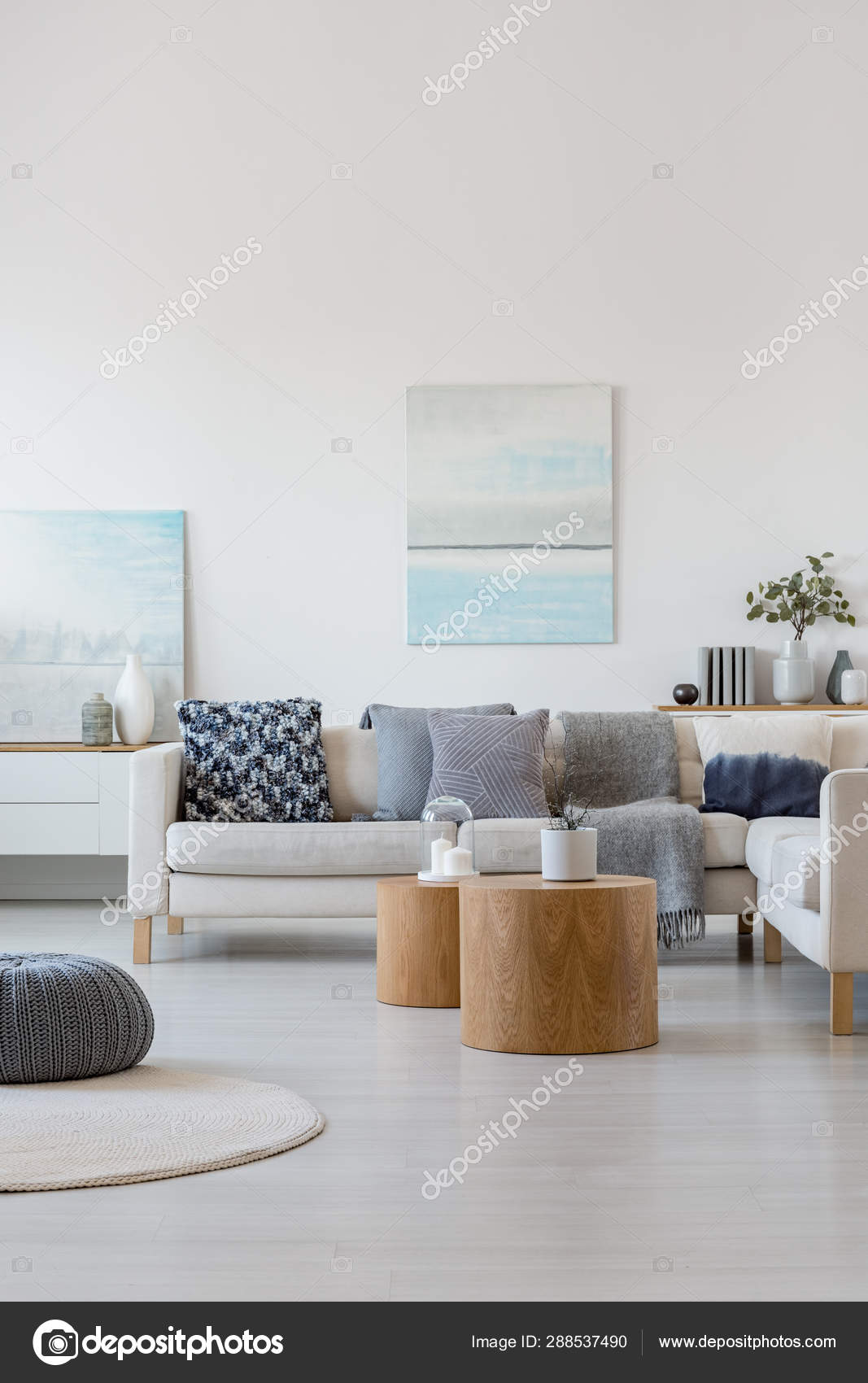 Two Wooden Coffee Tables With Plant In Pot In Front Of Grey