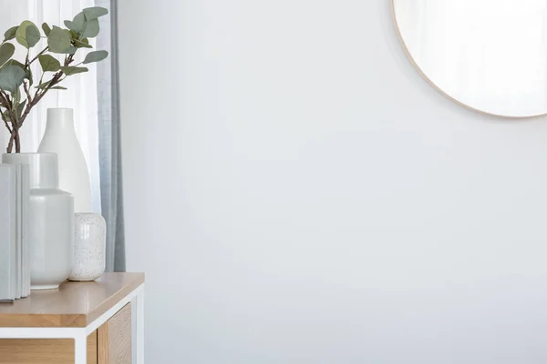 Espejo en marco de madera en la pared blanca del interior de la sala de estar de moda en apartamento luminoso — Foto de Stock