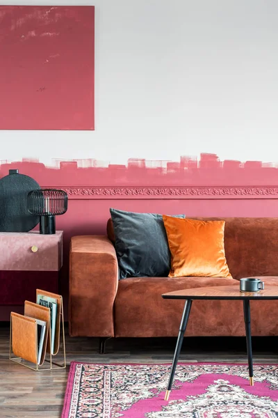 スタイリッシュなリビングルームのインテリアに茶色のソファにオレンジ色の枕、スエードのコンモードと木製のコーヒーテーブル — ストック写真