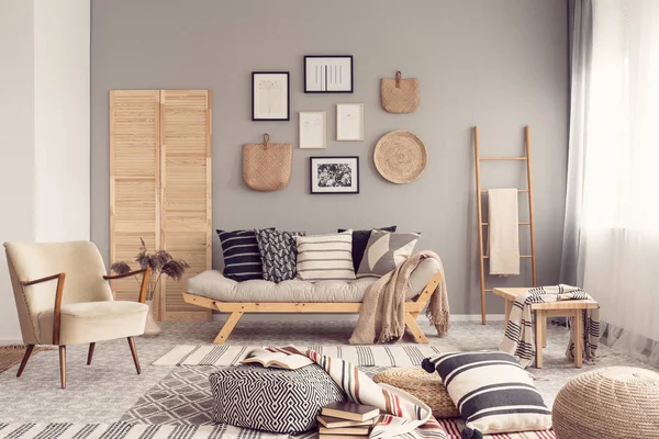 Стильный дизайн интерьера гостиной со скандинавским диваном, серой стеной и природными акцентами — стоковое фото