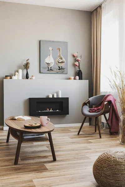 Cookies and pink team mug on wood coffee table in grey living room interior with eco fireplace and chic chair — Stok Foto