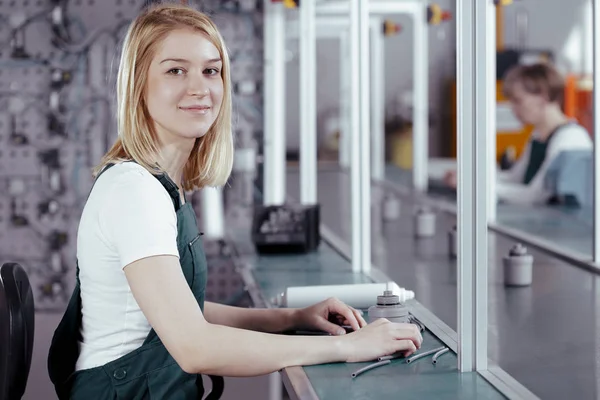 Närbild av koncentrerad ung kvinnlig arbets tagare i denim övergripande arbetar på fabriken — Stockfoto