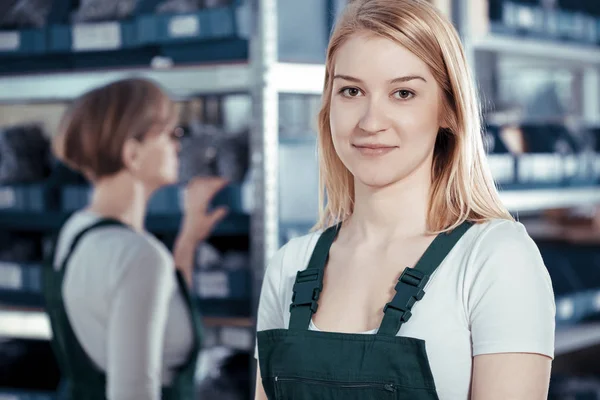 Joven rubia trabajadora de fábrica vistiendo uniforme verde en el trabajo — Foto de Stock