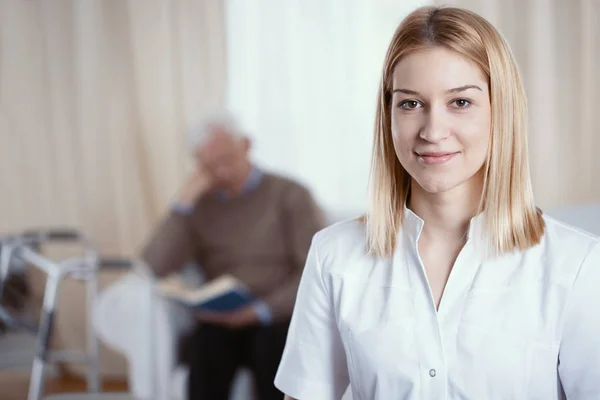 Красивая молодая медсестра с светлыми волосами и белой формой — стоковое фото