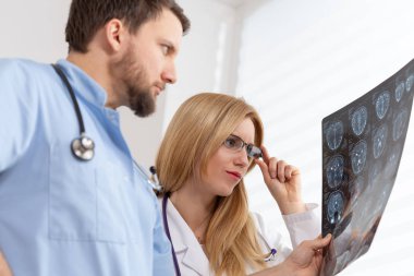 Genç kadın doktor ve yakışıklı erkek hemşire x-ray muayenesi bakıyor