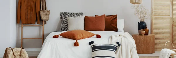 Intérieur confortable de la chambre avec oreillers, lit et cavalier sur un cintre. Une vraie photo — Photo