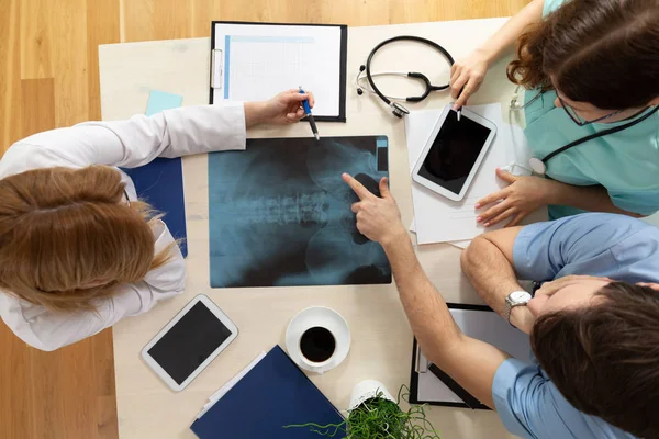 Draufsicht auf den gemeinsamen Schreibtisch mit Röntgenuntersuchung und Notizen in der Arztpraxis — Stockfoto