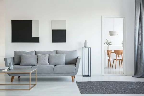 Abstract zwart-wit schilderij op lege muur van stijlvolle woonkamer interieur met comfortabele grijze bank met kussens — Stockfoto