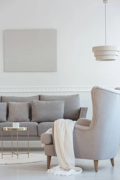 Poltrona traseira da asa confortável grande ao lado do sofá longo cinzento escandinavo com travesseiros no interior brilhante da sala de estar — Fotografia de Stock