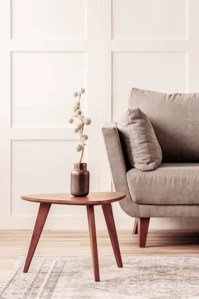 Flor de algodón en jarrón sobre mesa de centro de madera junto al sofá gris — Foto de Stock