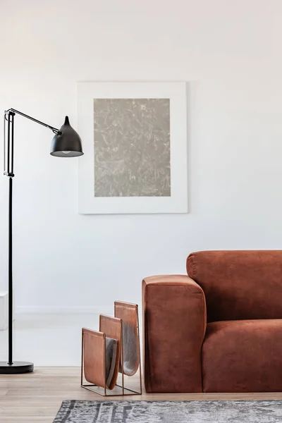 Black industrial lamp next to fashionable scandinavian sofa in bright living room interior — Stock Photo, Image