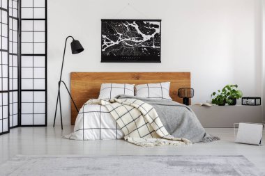 Sade yatak odası iç ahşap headboard üzerinde beyaz duvar üzerinde siyah harita
