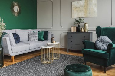 Duvarda soyut boyama ile şık zümrüt yeşili ve gri oturma odası iç tasarımı