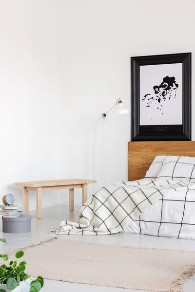 Elegante slaapkamer met witte muur en geblokt beddengoed — Stockfoto