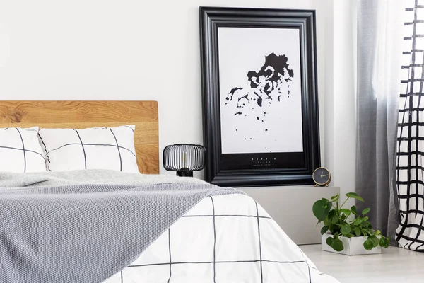 Zwart-wit kaart in zwart frame in trendy slaapkamer interieur met geblokte slaapkamer — Stockfoto