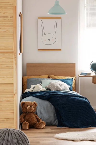 Brown cute teddy bear on wooden floor of stylish bedroom interior for kids — Stock Photo, Image