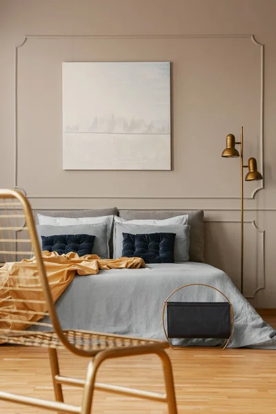 Elegante lampada dorata accanto al letto king size con lenzuola blu e cuscini blu scuro — Foto Stock