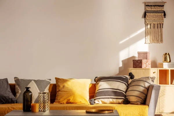 Kopiuj przestrzeń na pustej białej ścianie modnej wnętrza salonu z żółtymi i pomarańczowymi akcentami — Zdjęcie stockowe