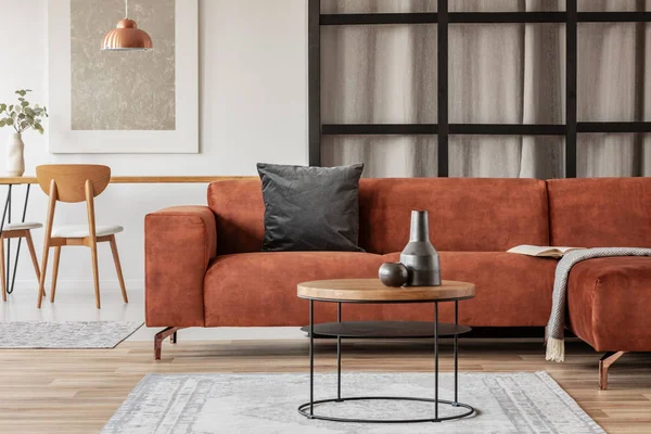 Stylish corner sofa with black pillow in open space studio apartment — Stock Photo, Image