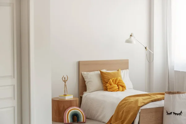 Белое и желтое постельное белье на одноместной деревянной кровати в современном интерьере отеля — стоковое фото