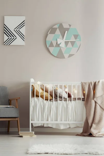 Schattig, Scandi slaapkamer interieur voor een kind met een witte wieg, pastel muur en een ronde klok. Echte foto — Stockfoto