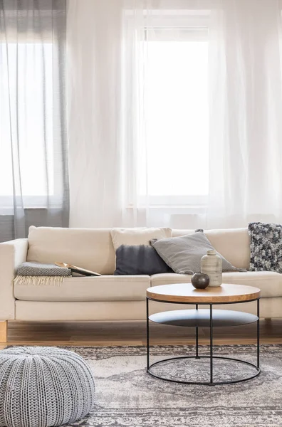 Стильный интерьер гостиной с диваном и журнальным столиком в светлой квартире — стоковое фото