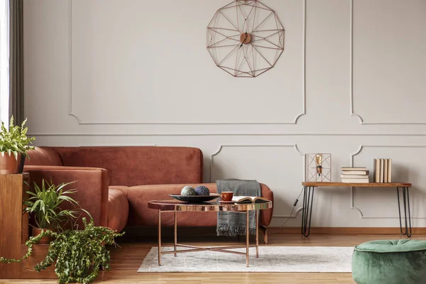 Comodo divano angolare marrone in elegante soggiorno interno con parete grigia con modanatura e orologio fantasia — Foto Stock