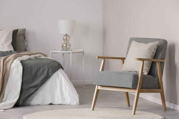 Fauteuil rétro tendance avec oreiller dans la chambre spacieuse intérieur avec lit king size et lampe sur table de chevet — Photo