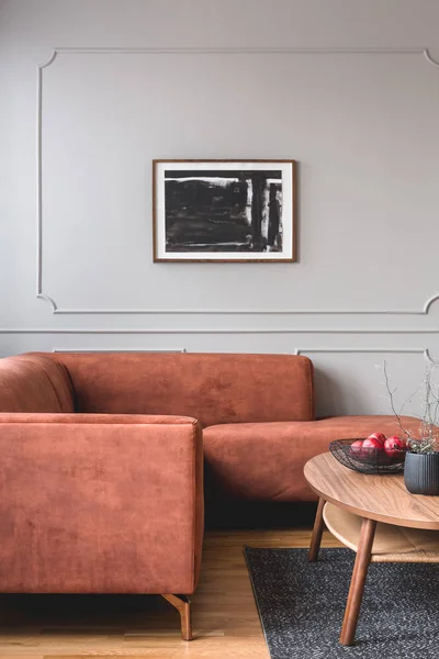 Květiny v vázu a červené plody v nádobě na dřevěné kávové stolek v elegantním interiéru obývacího pokoje se zázvorovou pohovkou — Stock fotografie