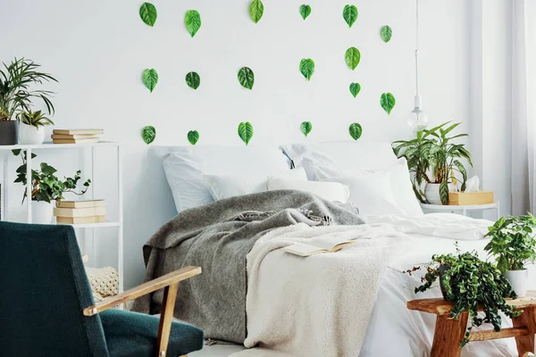 Sillón retro en el interior del dormitorio moderno con ropa de cama acogedora en la cama caliente — Foto de Stock