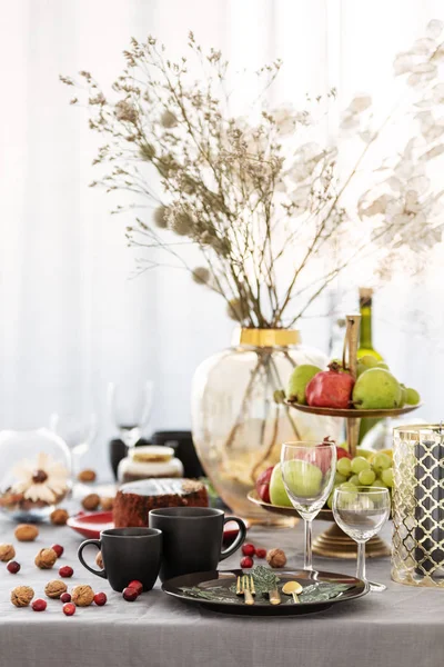 Mesa de comedor común con comida, frutas, tarta y flores en jarrón —  Fotos de Stock