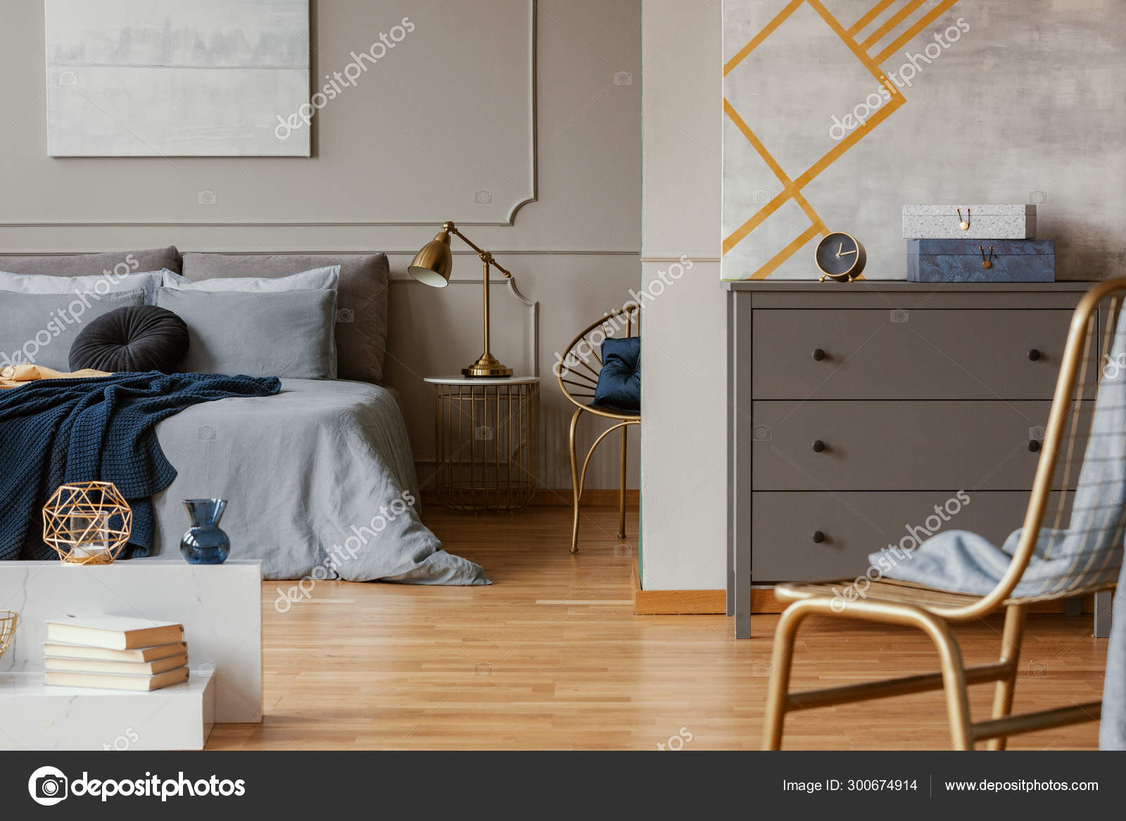 Trendy Bedroom Interior With Grey Commode And Golden Chair